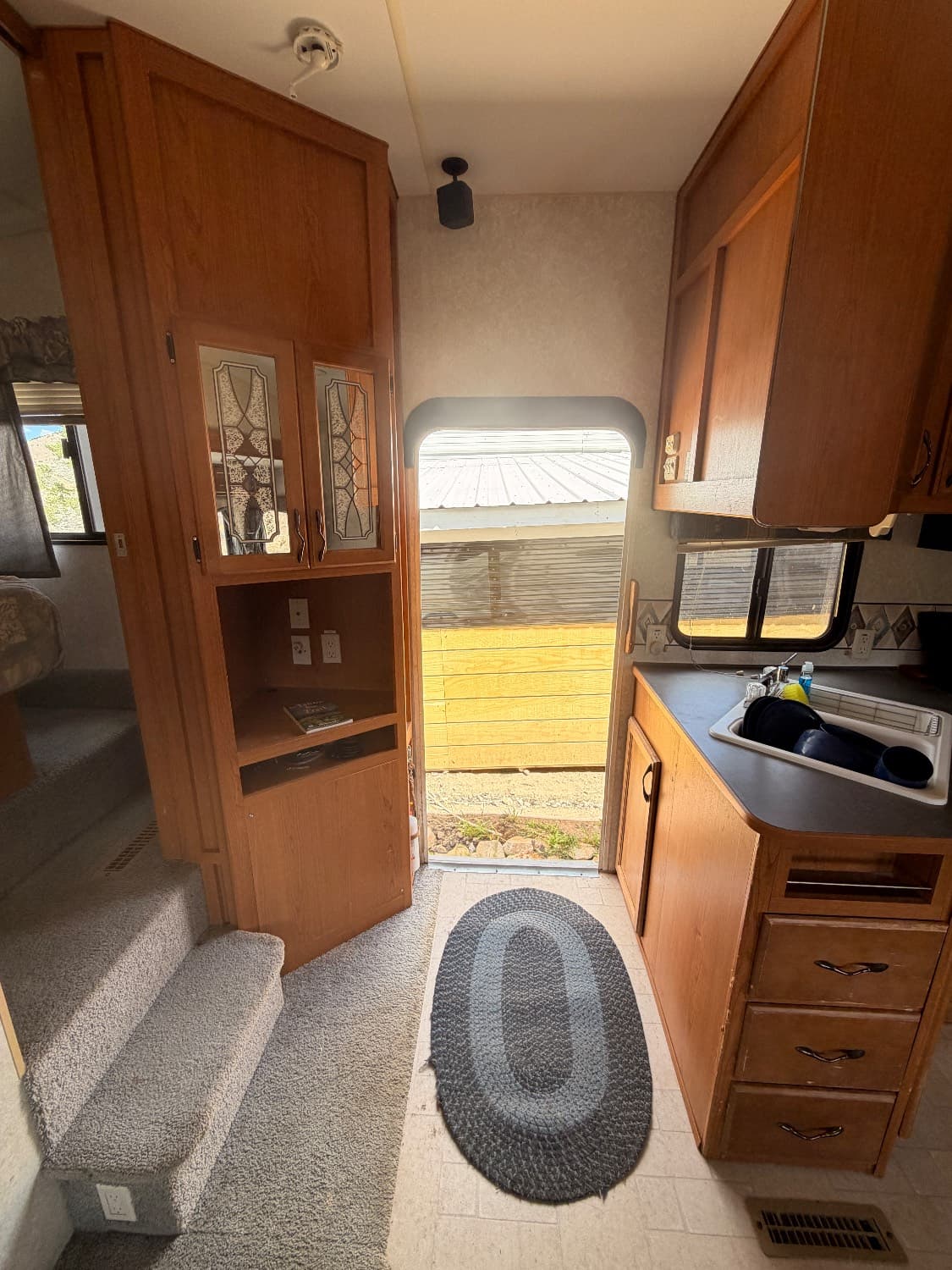 The entry of The Quantum looking toward the kitchen sink, with carpeted steps leading up to the front bedroom